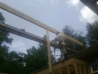 Carpenter setting a ridge beam over a new addition frame — Ice Dam Removal by Roofing Brothers in Sutersville