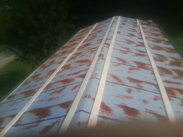 Rusted metal roof panels with new wood purlins before replacement — Storm Damage Roof Repair in Sutersville by Roofing Brothers