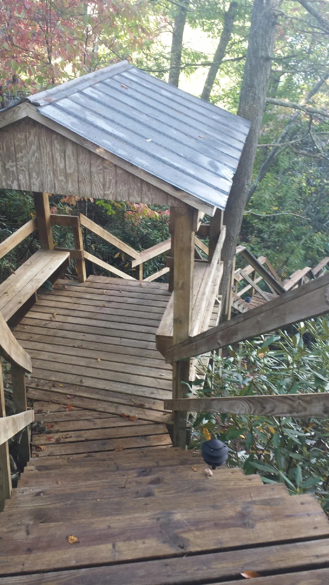 Metal roofed shelter over wooden steps on a wooded walkway — Skylight Repair & Installation work by our crew in Sutersville