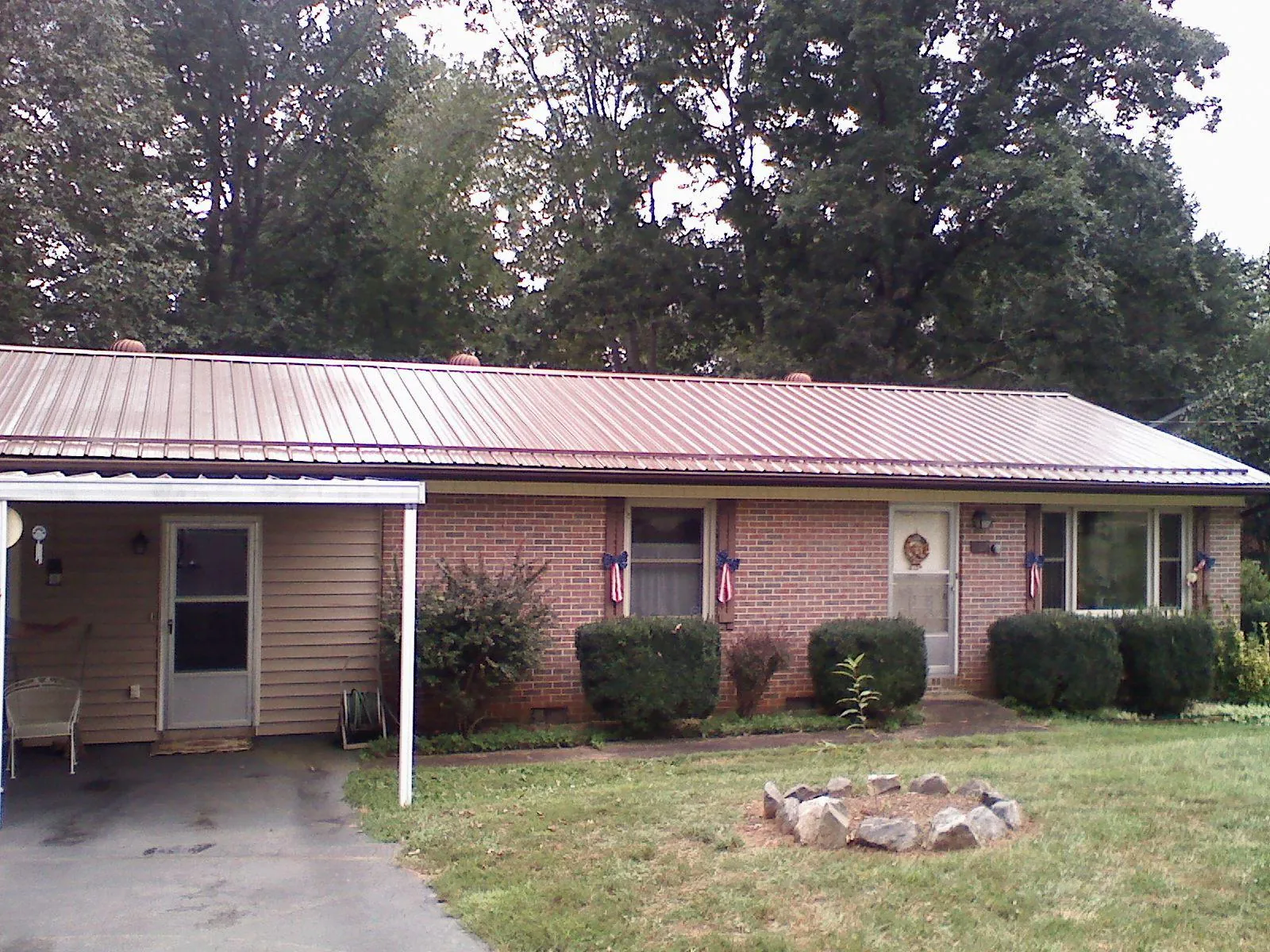 Bronze metal roof and carport on a brick ranch home — Roof Repair work by our crew in Sutersville
